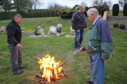 Mężczyźni odpalają od ognia drewniane 'ogniówki'